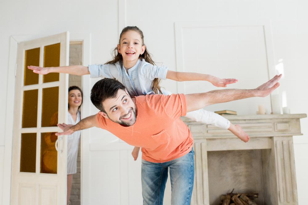 People Family of 3 Daughter Flying on Dad Fireplace